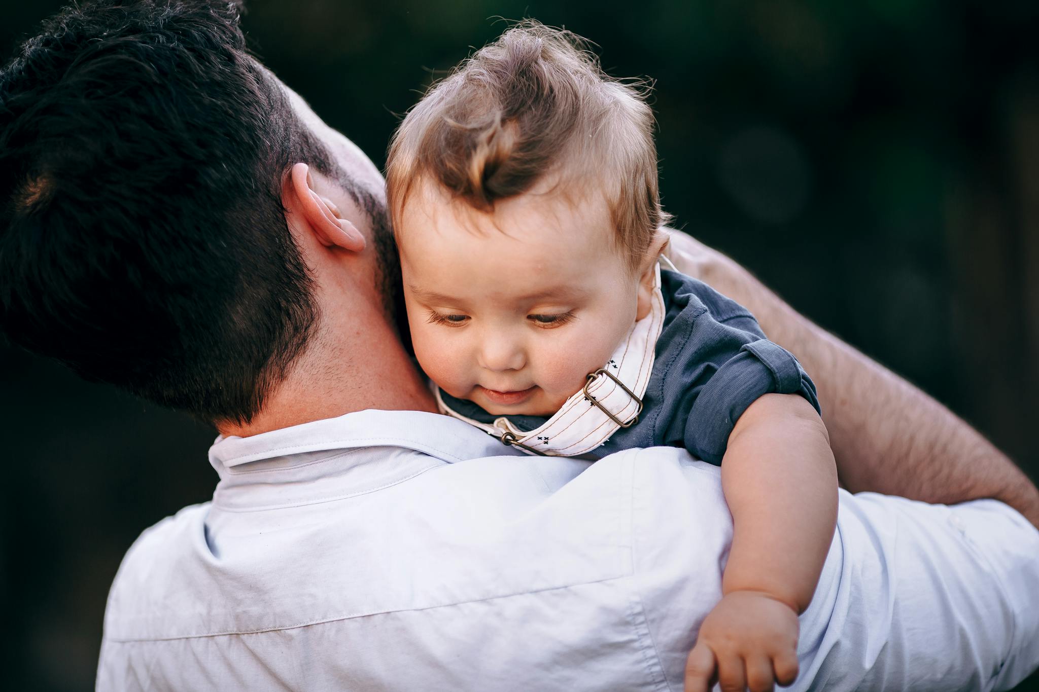 A warm moment capturing a father holding his baby outdoors during the day.